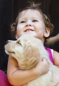young girl holding puppy